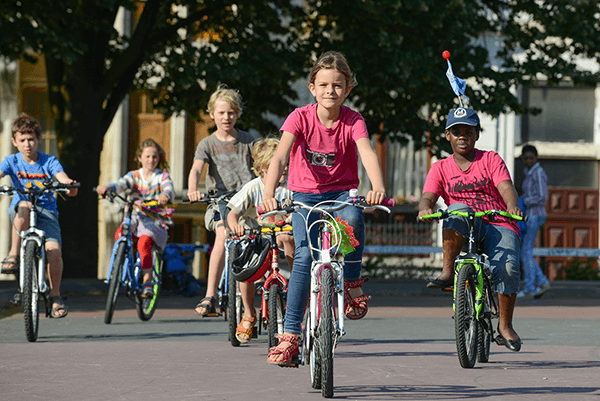 Groepje kinderen met meisje voorop fietsen samen