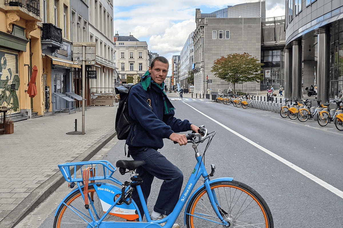 Julian Devos staat naast een blue-bike in Brussel